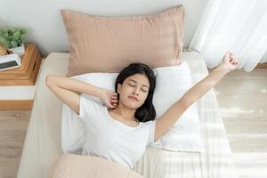 Simple lifestyle, Asian woman wakes up from good sleep on weekend morning, takes some rest, relax in comfortable bedroom at hotel window, happy lazy day, enjoy work life balance photo