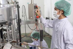quality supervisor of food or beverages technician change parameter and condition control food or beverages before send product to the customer. Production leader recheck machine and productivity. photo
