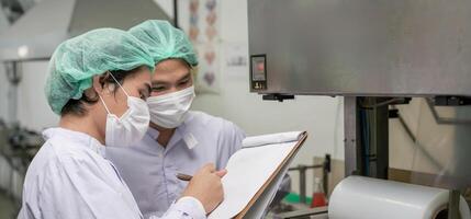 quality supervisor or food or pharmaceutical technician discuss about process control of food and drugs before send product to the customer. Production leader recheck parameter and productivity photo