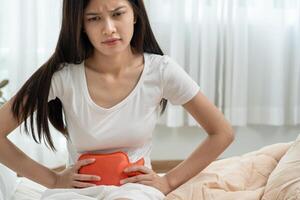 stomach ache. Asian women have abdominal pain, indigestion, gastritis, menstrual cramps, flatulence, diarrhea, distention, colon cancer, belly inflammation problem. suffer food poisoning. photo