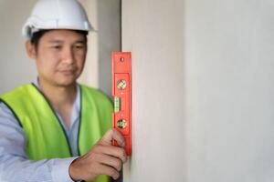 Contactor inspecting construction and quality assurance new house using a level. Engineers or architects or contactor work to build the house before handing it over to the homeowner photo