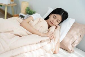 Asian woman sleep well from good sleep on weekend morning, takes some rest, enjoy relax in comfortable bedroom at home window, happy lazy day, enjoy work life balance photo