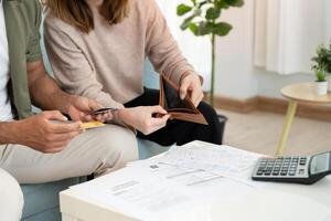 Stress and headache asian couple with large bills or invoices no money to pay to expenses and credit card debt. shortage, Financial problems, mortgage, loan, bankruptcy, bankrupt, poor, empty wallet. photo