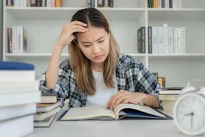 Asia student woman have anxiety because of exams, female prepare for test and learning lessons in the library. stress, despair, haste, misunderstanding reading, discouraged, expectation, knowledge photo