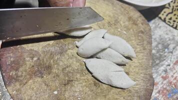 A person cutting up some dough on a cutting board video