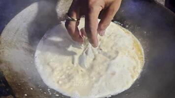 A person is cooking a pancake in a frying pan video