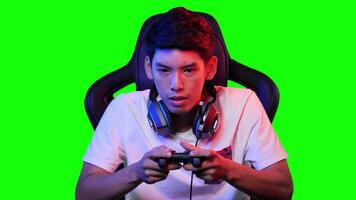 Young male gamer intensely playing games on green screen background. video