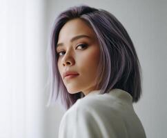 Young woman with lavender hair facing the camera in neutral light photo