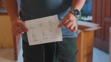 Person Holding Instruction Sheet for DIY Project video