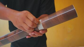 Person Holding a Rolled-Up Wooden Texture Poster video