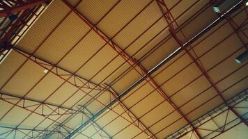 A close-up view of a large industrial roof structure featuring metal beams and corrugated panels. The design showcases a geometric pattern with a focus on the intersecting lines and textures. video