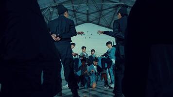 Group of young dancers practicing in an industrial-looking hall, displaying energy and movement in casual attire. video