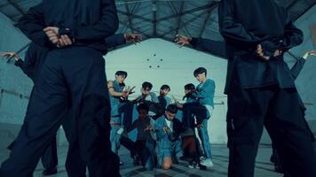 Diverse group of young people dancing in an industrial-style room with cool video