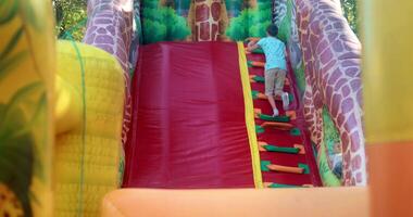 Child Climbing Inflatable Slide at Outdoor Playground video