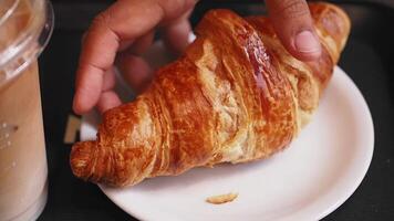Delicious croissant and iced coffee in cozy cafe setting video