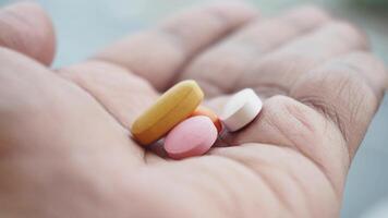 Hand holding various colorful pills and supplements video