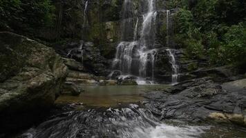 a waterfall in the jungle with rocks and water video