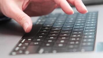 ein Nahansicht Schuss von ein Hand Tippen auf ein Laptop Klaviatur, betonen Digital Kommunikation, Technologie, und Fernbedienung arbeiten. video