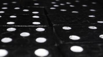 närbild se av svart domino plattor med vit prickar på texturerad yta i en strategisk spel miljö video