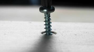 Close-up of Unscrewing a Metal Screw from Wooden Surface with Electric Screwdriver in Workshop Environment video