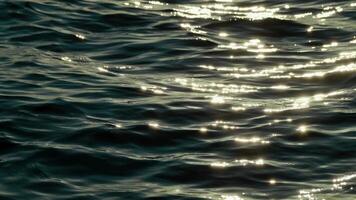 Abstract Close-Up of Sea Waves Glistening Under a Warm Sunset Glow on Ocean Surface video