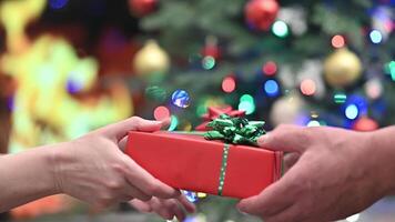 Joyful Exchange of Christmas Presents by a Cozy Holiday Fireplace with Decorated Tree in Background video