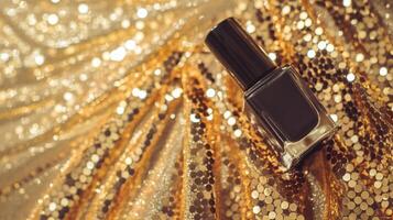 A sleek black nail polish bottle atop a shimmering gold backdrop, exuding elegance and luxury. photo