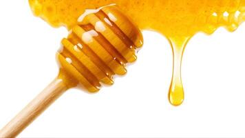 Golden honey drips from a wooden dipper with honeycomb against a white background. photo