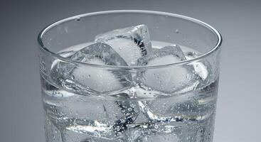 Macro close-up of glass with ice water, cold and realistic. photo