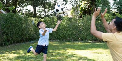 Child Throwing Soccer Ball. Joyful Playtime with Parent photo