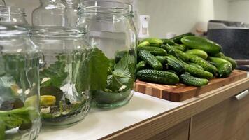 Glass jars are prepared for pickling with fresh cucumbers and herbs, capturing the essence of homemade preservation and culinary arts video