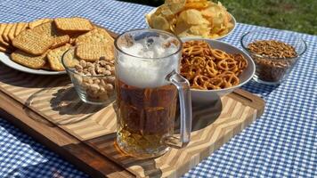 A picnic table with beer, pretzels, and snacks evokes Oktoberfest festivities, ideal for celebrating outdoors with friends video