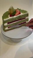 A slice of matcha cake with strawberries and cream, perfect for celebrations like birthdays or weddings features vibrant colors and layered textures video