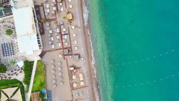 Drone photo of beach resort with umbrellas, sun loungers, and turquoise sea video