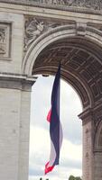 French flag under Arc de Triomphe with cloudy sky in Paris, France 06.08.2025 video