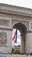French flag under Arc de Triomphe with tourists in Paris, France 06.08.2025 video
