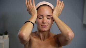 Palm glide across forehead in facial massage finale video