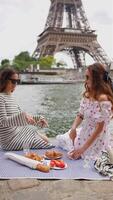 Two women enjoy picnic near Eiffel Tower Paris video