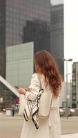 Woman with phone in modern business area from behind video