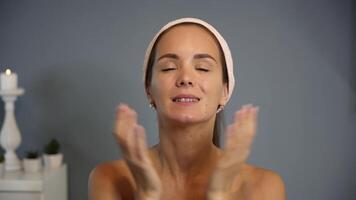 Smiling woman pats face after skincare routine video