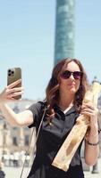 Close up of woman taking selfie with baguette in Paris video
