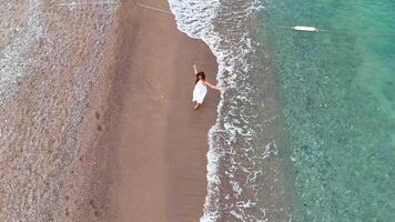 Top down aerial view of woman standing by sea at tranquil shoreline video