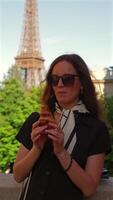Stylish woman eating croissant near Eiffel Tower video