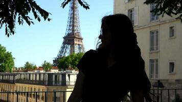 Silhouette of woman on balcony with Eiffel Tower view video