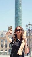Woman taking selfie with baguette at Place Vendome video