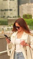 Smiling woman with coffee and phone in business area video