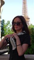 Woman adjusting scarf near Eiffel Tower in Paris video