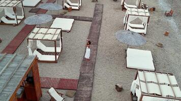 Top view of woman walking between sunbeds and cabanas video