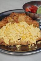 Scrambled eggs served in a flaky croissant at brunch photo