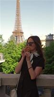 Woman eating croissant by Eiffel Tower in Paris video